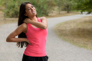 Young woman out jogging suffers a muscle injury